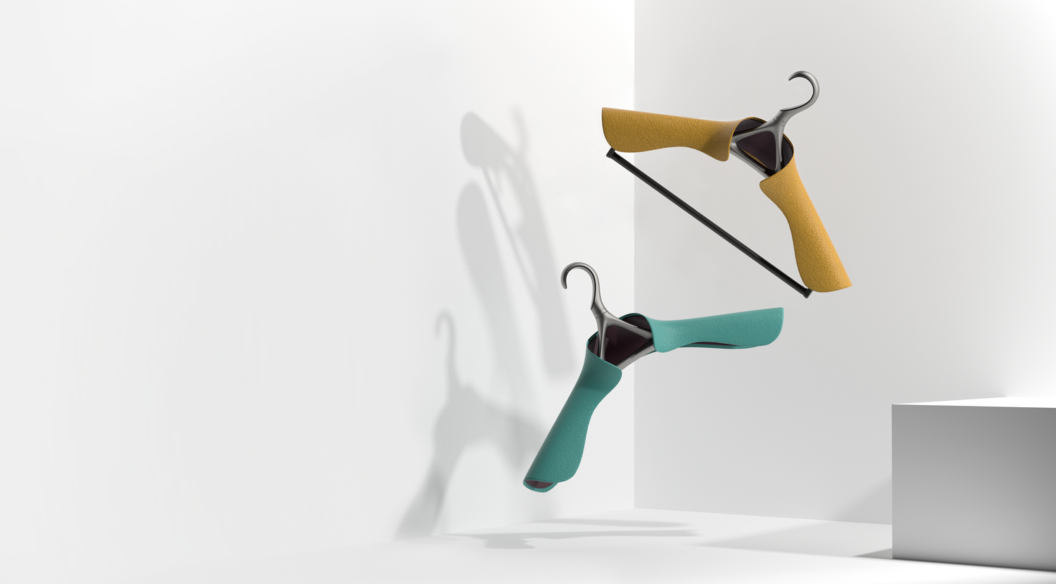 Image shows two Lou Hansell custom clothes hangers made for bespoke closets floating in mid air. One is crafted from a teal-colored Italian leather, the other a mustard.
