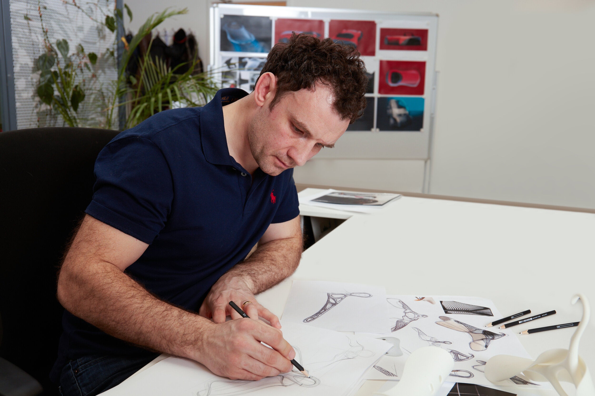 Designer sketching luxury hanger styles for Lou Hansell, reflecting sustainable craftsmanship and refined design.