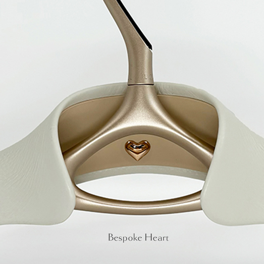 Close-up of Lou Hansell's L series luxury wedding dress hanger in Yellow Gold and Off-White with bespoke heart detailing.