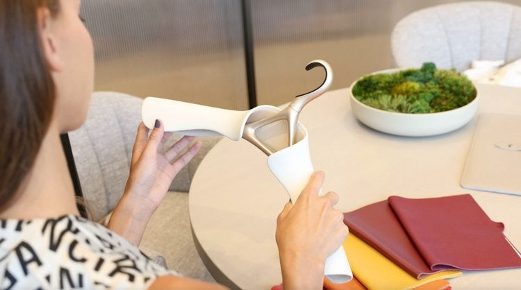 Woman holding white hanger with other color samples on the table