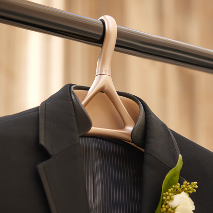 A suit jacket hanging on a Lou Hansell bridal collection H Series hanger wrapped in onyx leather