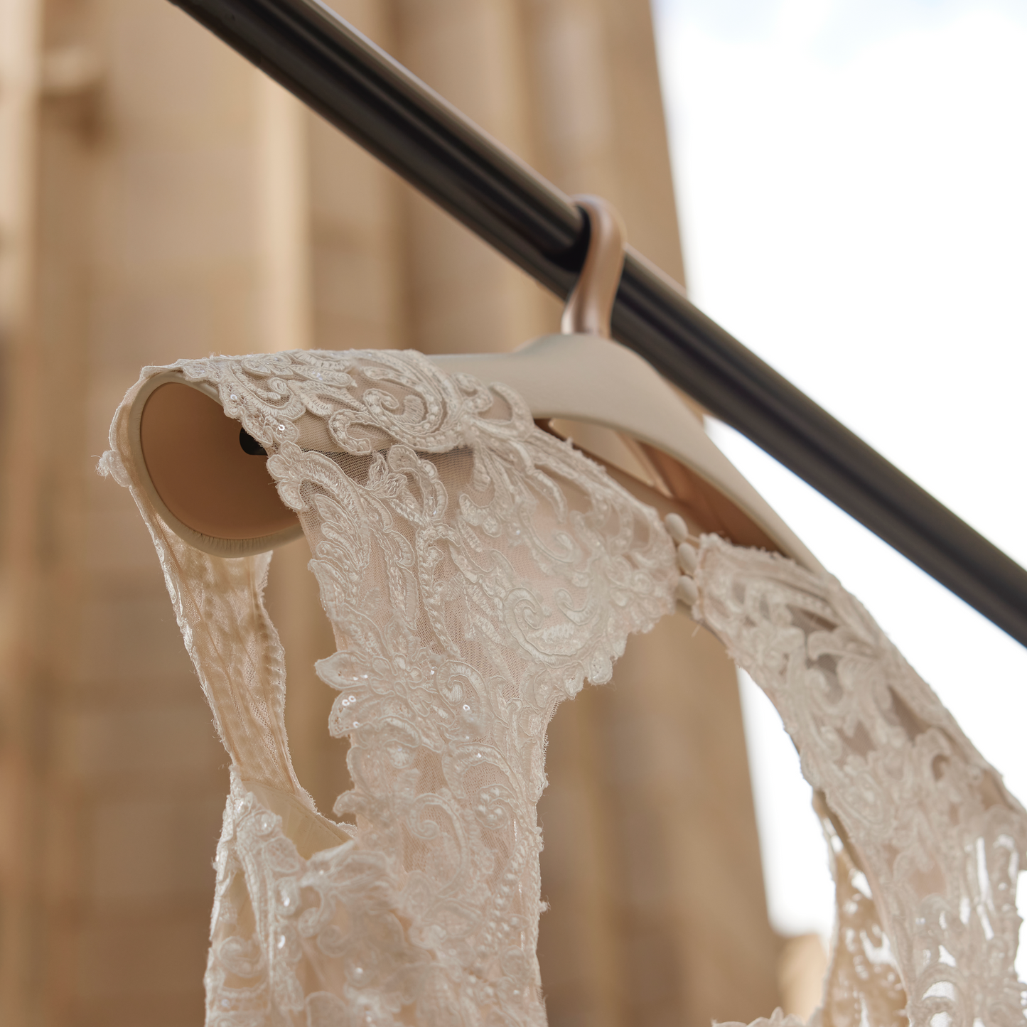 A wedding dress hanging from a ou Hansell bridal series hanger