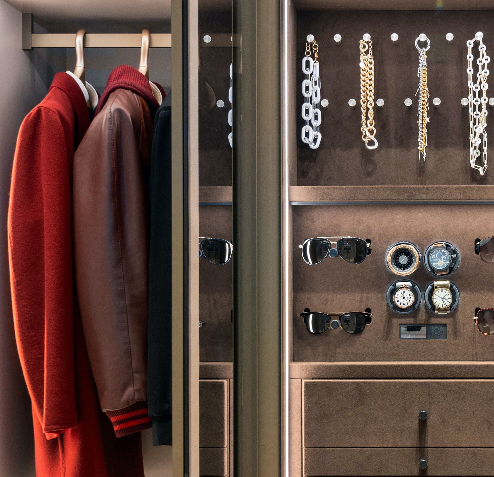 Custom closet with a red and brown jacket hanging and accessories