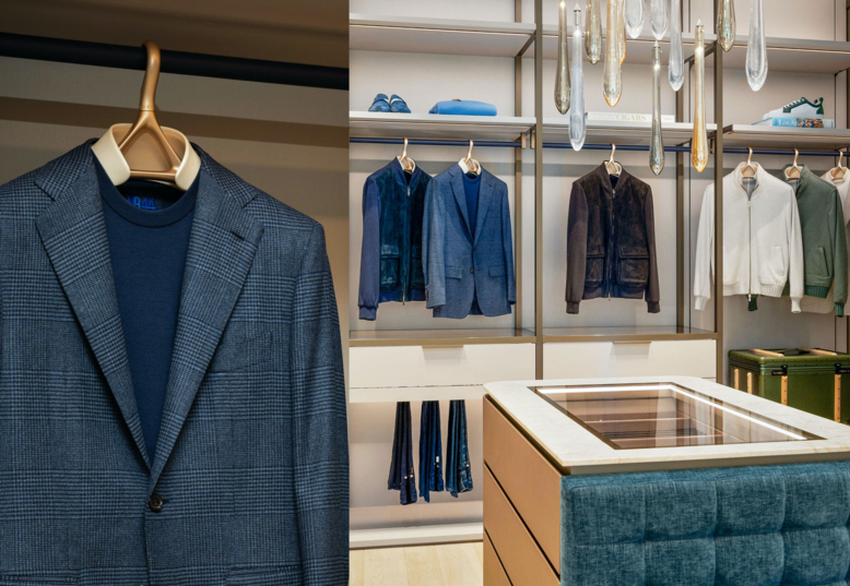 Mens navy colored suit next to a closet full of mens wear in mostly navy shades